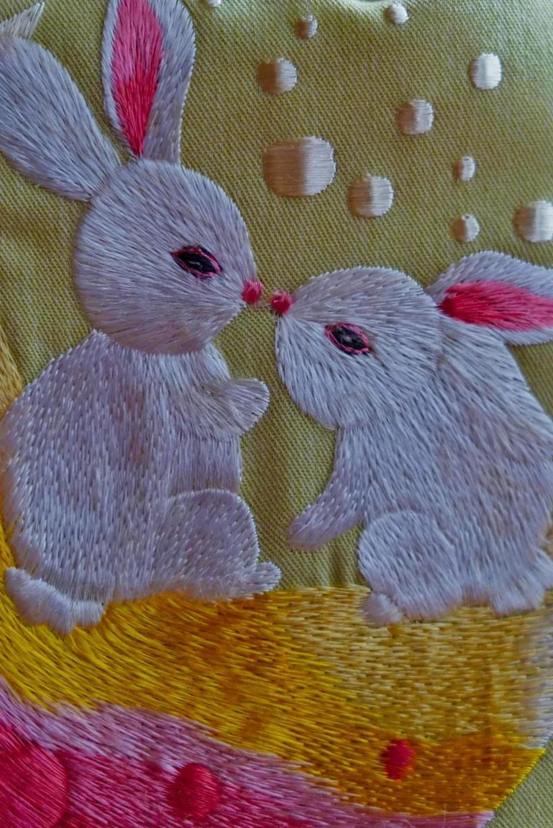 玉兔莲蓬手提包采用纯棉质地,结合刺绣方式展现两只玉兔在月中嬉戏.